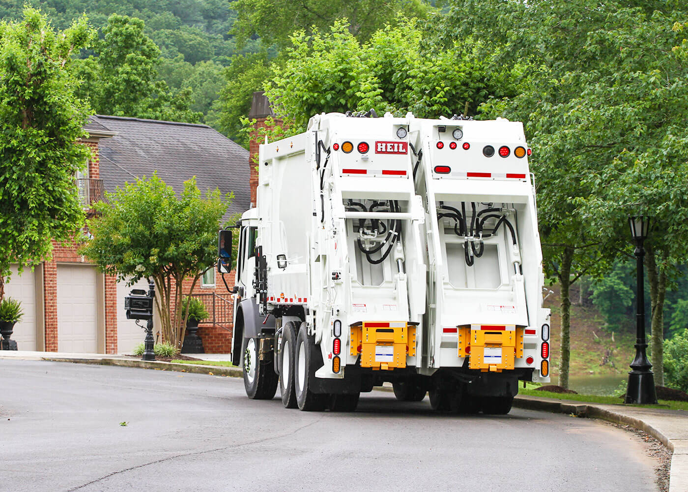 Rear loader trash truck with two compartment split for dual collection