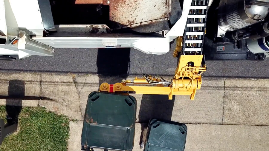 Sideload garbage truck arm spear feature to grab waste containers